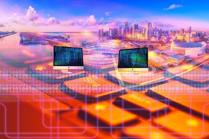 Reprodução de imagem de cidade que remete às funcionalidades de governo digital e/ou eletrônico, exemplificando a conectividade e tecnologia de uma smart city, por meio de ferramentas digitais. Imagem multicolorida e com predominância do laranja e azul